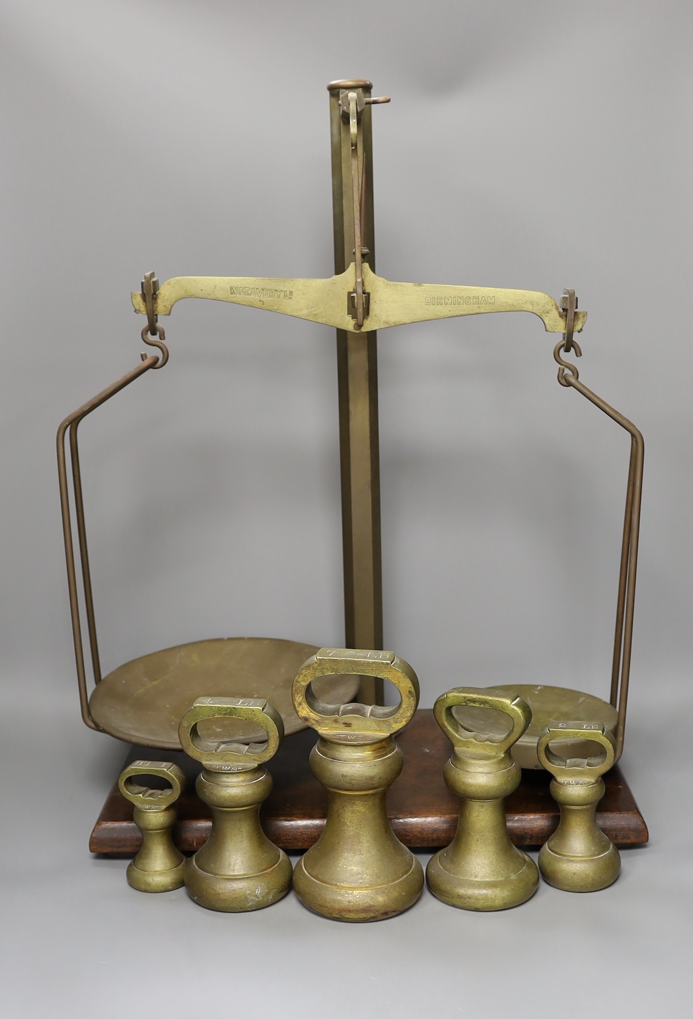 A set of grocer's scales by W&T. Avery Ltd., Birmingham with an 7 LB, two 4 LB, 2 LB and a 1 LB weights
